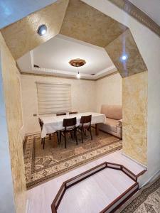 Habitación con mesa, sillas y cama en Naryn Cozy House en Naryn