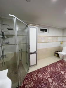 y baño con ducha y puerta de cristal. en Naryn Cozy House en Naryn