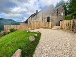 an old stone house with a fence and a yard at Stunning Home with STARGAZING ROOM Near Kielder Water in Greenhaugh