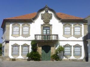 un grand bâtiment blanc avec une porte verte dans l'établissement Casa do Adro - Solar Corte Real - Turismo de Habitação, 