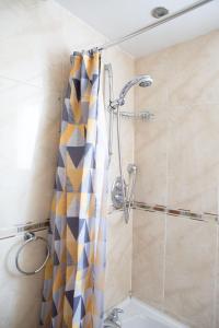 a shower with a shower curtain in a bathroom at Coach House in High Bentham