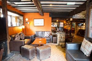 a living room with leather couches and a table at Coach House in High Bentham