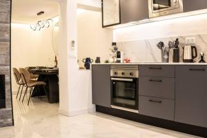 Il comprend une cuisine équipée d'une cuisinière et d'une table à manger. dans l'établissement Gran-Via Luxury Flat 3BD City Center + Terrace + AC, à Madrid