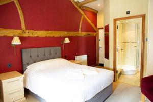 a bedroom with a white bed and a red wall at Coach House in High Bentham