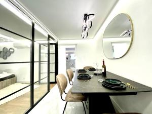 - une salle à manger avec une table et un miroir dans l'établissement Gran-Via Luxury Flat 3BD City Center + Terrace + AC, à Madrid