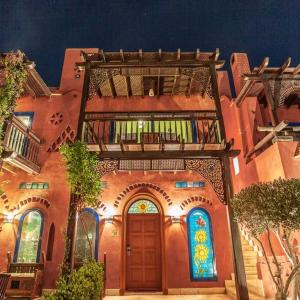 a building with a balcony and a door with stained glass at Lazib Inn Resort & Spa in ‘Izbat an Nāmūs