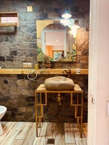 uma casa de banho em pedra com um lavatório e um espelho em Guest House OLD WALL em Lagodekhi