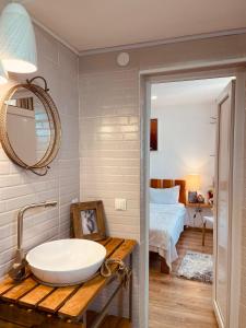 een badkamer met een wastafel en een slaapkamer met een bed bij Guest House OLD WALL in Lagodekhi