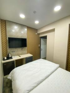 a bedroom with a white bed and a tv on the wall at FLORYA EXPRESS APART in Istanbul
