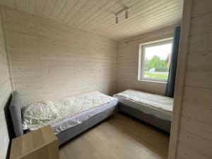 two beds in a room with a window at Domek Pod Brzozami 