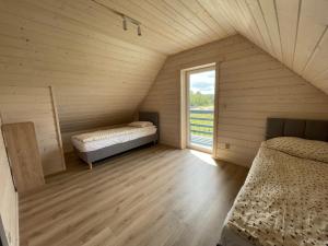 two beds in a room with a window at Domek Pod Brzozami 