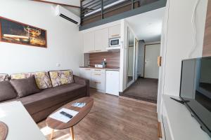 Atrijum Apartments and Rooms في كلادوفو: غرفة معيشة مع أريكة وطاولة