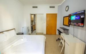 a room with a bed and a desk and a tv at Studios for Female in Dubai, Marina in Dubai