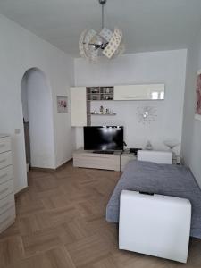 a white room with a bed and a flat screen tv at Appartamento Grandi in Peschici