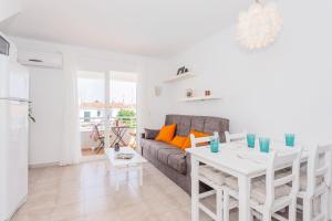 a living room with a white table and a couch at Cala'n Blanes Park 228 in Cala en Blanes