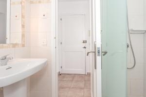 a white bathroom with a sink and a shower at Cala'n Blanes Park 228 in Cala en Blanes +12 photos