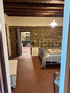 a bedroom with a bed and a stone wall at Case Vacanza Villa Bentivoglio in Piazza Armerina