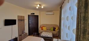 a hotel room with a couch and a chair at Luxury Apartments Ekaterina in Chernomorets