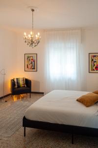 雷維內拉戈的住宿－Ca' Glera: Vintage Charm Apartament，一间卧室配有一张床、一把椅子和一个吊灯。