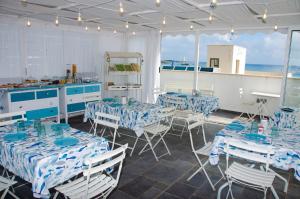 a room with blue and white tables and chairs at Le Stelle Sea Rooms in San Vito lo Capo