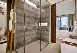 The St. Regis Downtown Dubai في دبي: حمام مع دش مع مرحاض وغرفة نوم