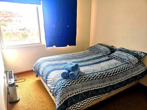 Valparaiso Primera Linea في فالبارايسو: وجود دمية دب زرقاء على سرير في غرفة النوم