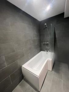 a bathroom with a white tub and a shower at Stunning Home with STARGAZING ROOM Near Kielder Water in Greenhaugh