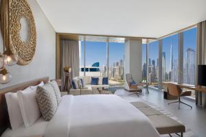 The St. Regis Downtown Dubai في دبي: غرفة نوم بسرير كبير وغرفة معيشة
