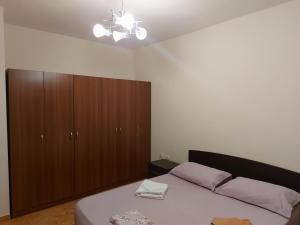 ein Schlafzimmer mit einem Bett und einem großen Schrank in der Unterkunft Mano' s Place in Tirana
