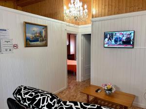 Una sala de estar con un sofá y un televisor en una pared. en Bungalows & Albergue La Playa, en Logroño
