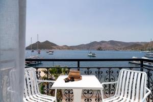 Grikos的住宿－銀灘酒店，阳台上的一张带帽子的桌子和两把椅子