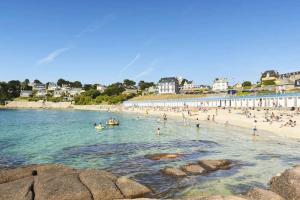 un groupe de personnes dans l'eau sur une plage dans l'établissement Longère Bretonne près du GR34, à Trébeurden