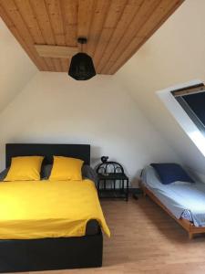 um quarto com uma cama com lençóis amarelos e um tecto em Longère Bretonne près du GR34 em Trébeurden