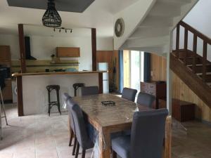une salle à manger avec une table et des chaises et une cuisine dans l'établissement Longère Bretonne près du GR34, à Trébeurden 24 autres photos