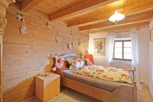 a bedroom with a wooden wall with a bed at Der Birkenhof-Ried in Pfaffing