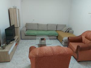 ein Wohnzimmer mit einem Sofa und 2 Stühlen in der Unterkunft Mano' s Place in Tirana