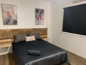 una camera con letto e TV a schermo piatto di draper a South Hedland