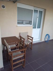 a patio with a table and chairs and a window at Studios Anastasia in Néa Koútali +5 photos