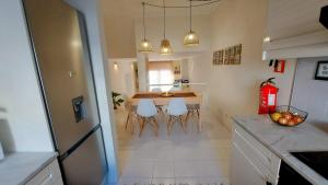 een keuken en eetkamer met een tafel en stoelen bij All Dreams Apartment - Urbanização Windmill in Albufeira