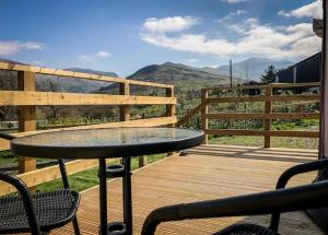 a table on a deck with a view of a mountain at Glamping in Llanberis in Llanberis