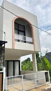 Casa blanca con ventana y balcón en homestay Bumisarehat en Citeureup 1