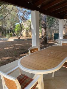 einen Holztisch und Stühle auf einer Terrasse in der Unterkunft Villa Romana in Santa Maria di Leuca