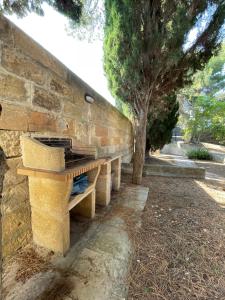eine Reihe von Bänken neben einer Ziegelmauer in der Unterkunft Villa Romana in Santa Maria di Leuca