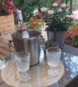 a bottle of wine and two glasses on a table at Chambre climatisée au cœur de brive avec téléviseur connecté wifi Netflix in Brive-la-Gaillarde