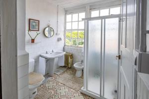 baño con lavabo y aseo y ventana en Casona de la Ribeira Sacra en Pobra do Brollón