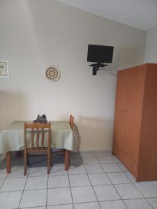 a room with a table and a television and a chair at Studios Anastasia in Néa Koútali
