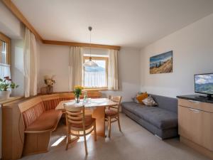 a living room with a table and a couch at Apart Magdalena in Hainzenberg