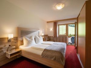 ein Hotelzimmer mit einem großen Bett und einem Fenster in der Unterkunft Apart Magdalena in Hainzenberg