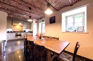 una cucina e una sala da pranzo con tavolo e sedie in legno di Le gîte de Froidefontaine a Havelange
