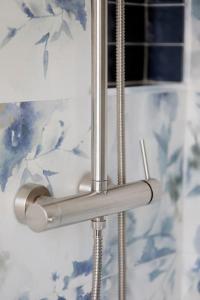 - un rideau de douche dans la salle de bains ornée de fleurs bleues dans l'établissement 55Birds - San Siro ed il centro a portata di mano, à Milan